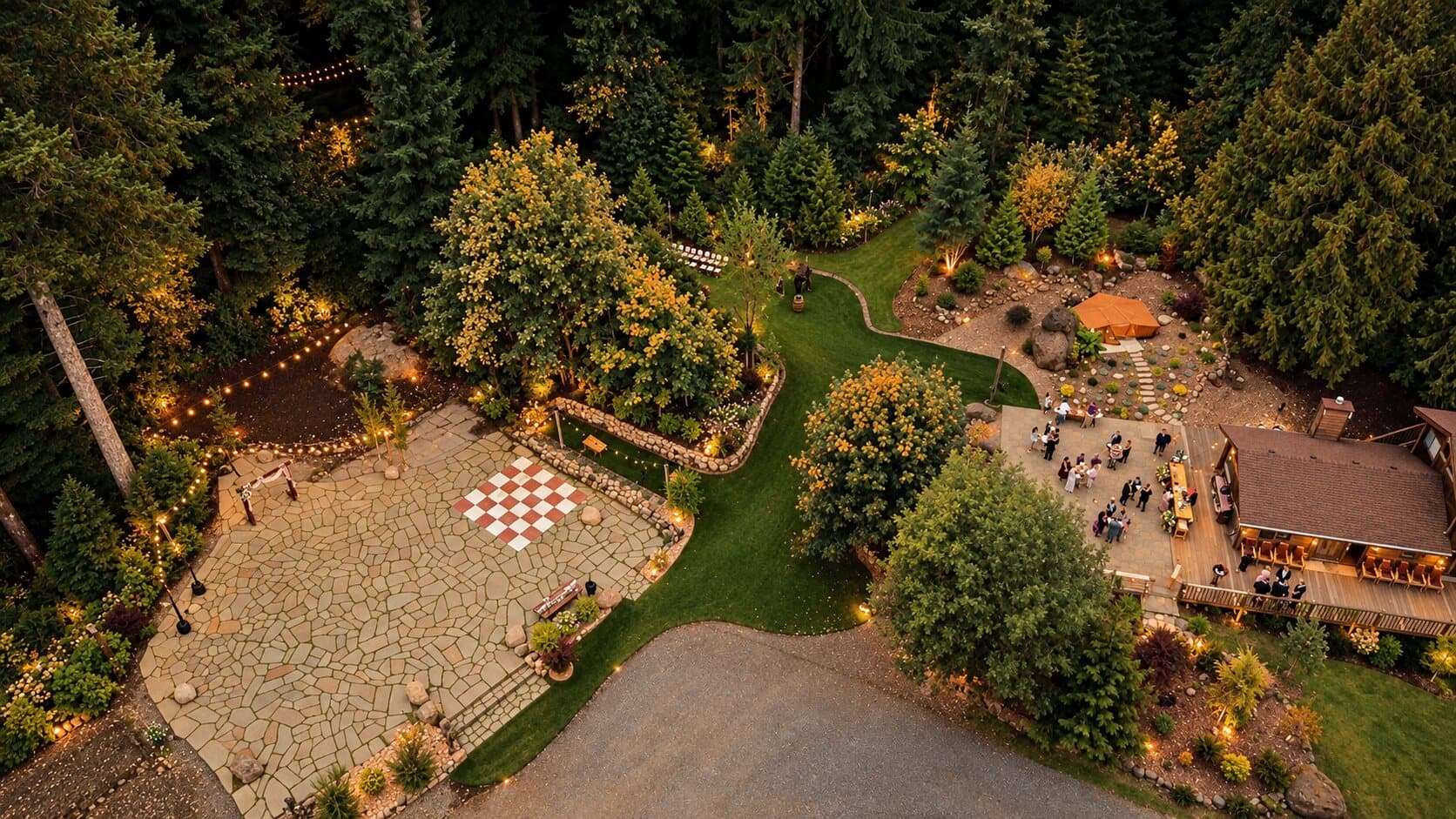 Styled aerial view of Highland Farms at dusk: the flagstone patio and dance floor, the lawn path and guests outside the Lodge