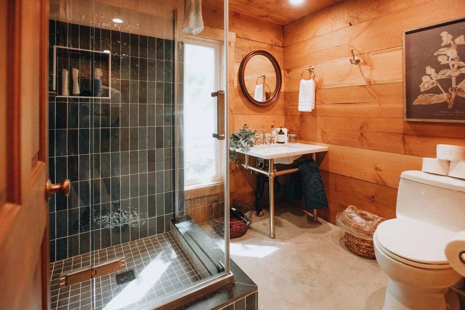 Bathroom with glass shower and dark tile