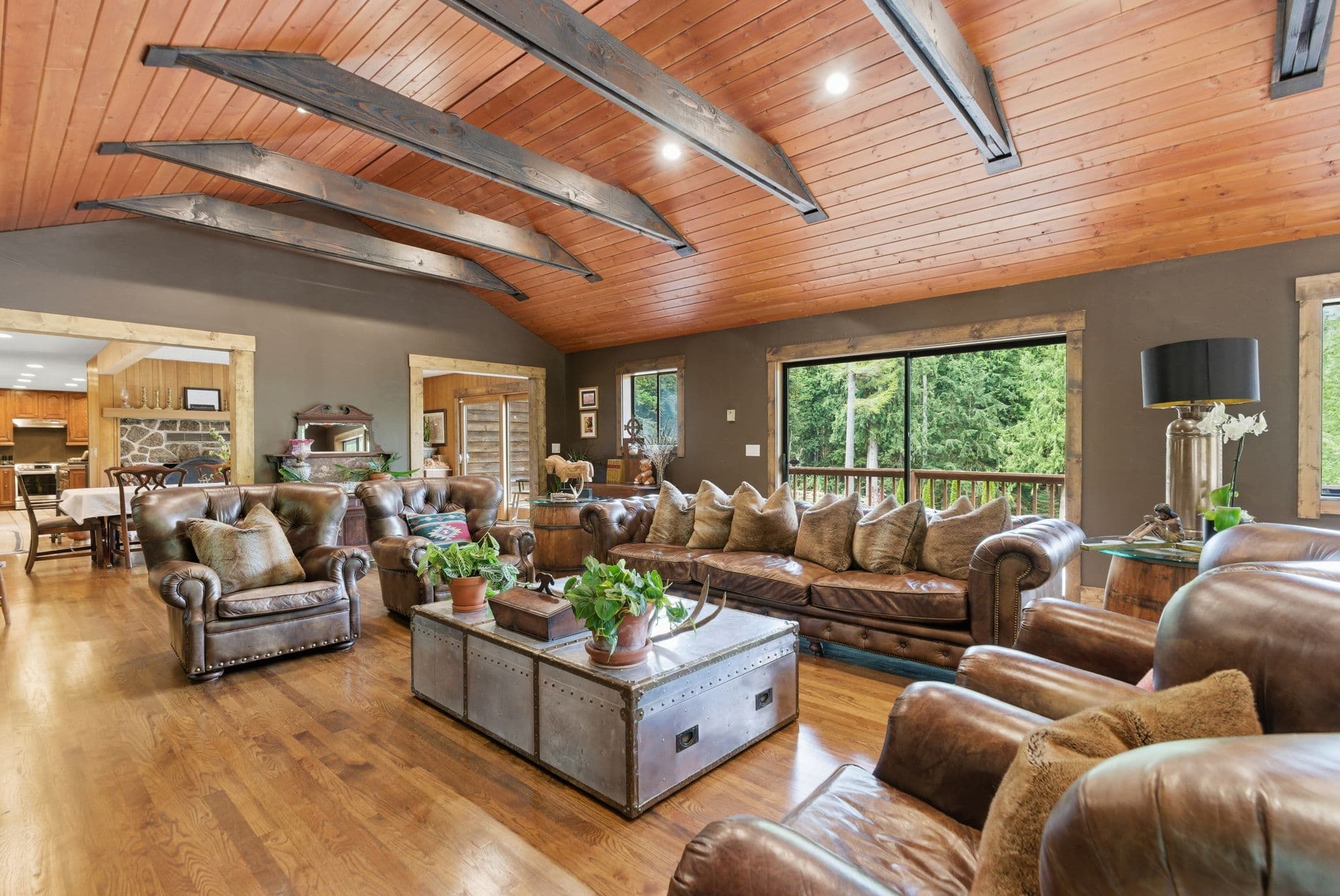 Living room with Chesterfield sofas, a curved iron-truss ceiling and a stone fireplace