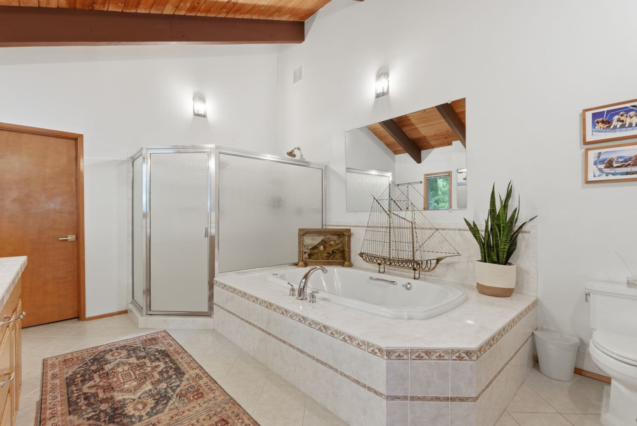 Master bathroom with a vaulted wood ceiling, soaking tub and glass shower