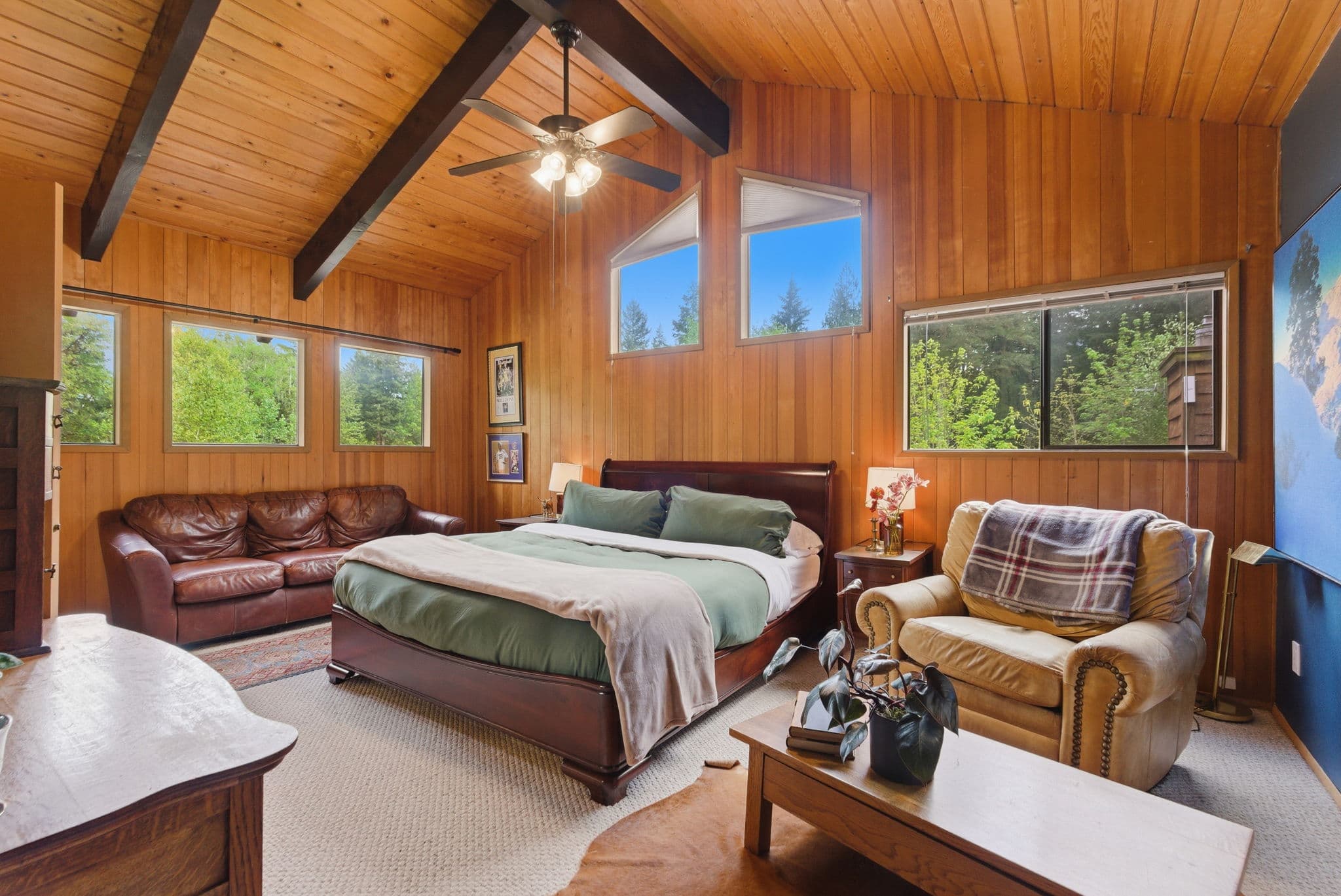 Master bedroom with vaulted cedar ceiling, king bed and a forest-view sitting area