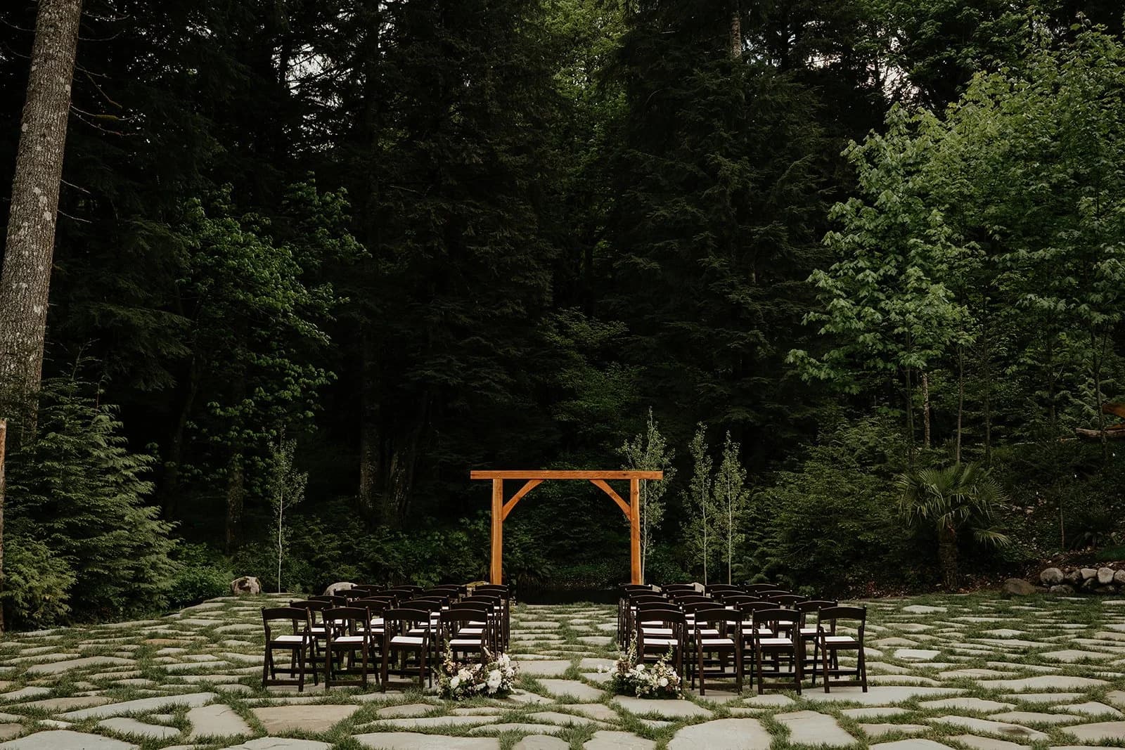 Forest ceremony setup with wooden arch